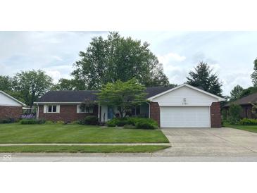 Charming brick ranch home features a two-car garage and a lush green lawn at 1701 Beech N Dr, Plainfield, IN 46168