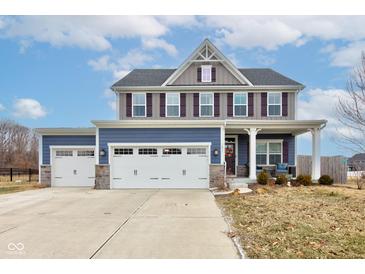 Charming two-story home featuring a three-car garage, blue and gray siding and a cozy front porch at 2627 Chalbury Dr, Plainfield, IN 46168