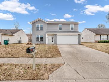 Charming two-story home with gray siding, a two-car garage, and a well-manicured lawn at 878 Hollowood Ln, Avon, IN 46123