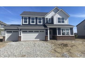 Charming two-story home with blue siding, white trim, and a spacious three-car garage at 8915 Alexander Rdg, McCordsville, IN 46055