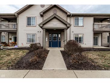 Charming condo exterior with a blue entry door, covered entrance, and well-maintained landscaping at 9820 Legends Creek Dr # 103, Indianapolis, IN 46229