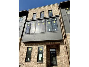 Newly built home with brick exterior, modern windows, and stylish architectural details on a sunny day at 124 1St. Se Ave, Carmel, IN 46032