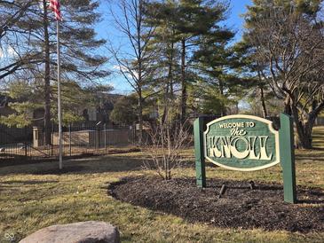 Welcome to The Knoll community sign with manicured lawn and mature trees creates a warm inviting atmosphere at 2207 Rome Dr # B, Indianapolis, IN 46228