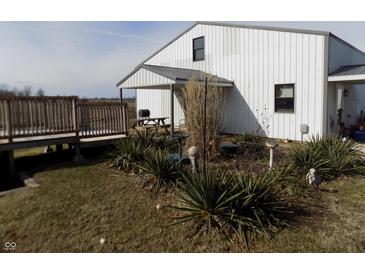 Charming two-story white home featuring a covered porch and a beautifully landscaped front yard at 3060 N Alaska Rd, Cloverdale, IN 46120