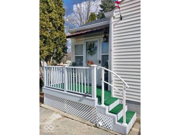 Charming front porch with a white railing, green turf, and decor at 5317 E 20Th Pl, Indianapolis, IN 46218