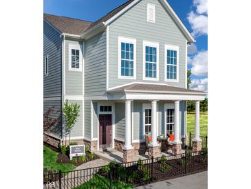 Charming two-story home featuring a covered porch with stone accents and a well-manicured front yard at 746 Astor Dr, Carmel, IN 46032