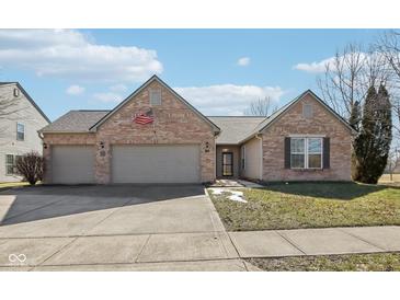 Charming brick home featuring an attached two-car garage and manicured front yard at 8535 Fenton Tower Dr, Indianapolis, IN 46259