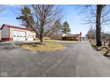 Property view showcasing a large driveway, an auxiliary garage, and a ranch style home at 1001 N 750 W, Bargersville, IN 46106
