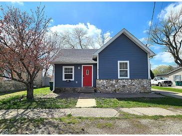 Charming blue home with stone accents, bright red door, and a well-maintained front yard under a sunny blue sky at 422 Johnson Ave, Franklin, IN 46131