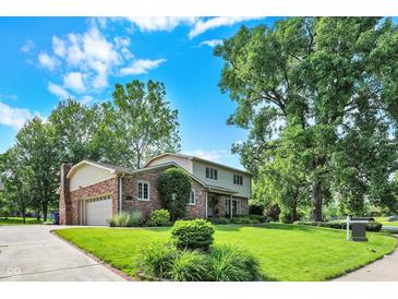 Beautifully landscaped two-story home with a brick facade, attached garage, and verdant lawn at 502 Ironwood Dr, Carmel, IN 46033