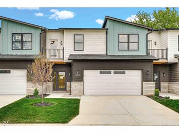 Beautiful townhome featuring modern architecture, a two-car garage, and a well-maintained front lawn at 5874 Harbour Town Dr, Noblesville, IN 46062
