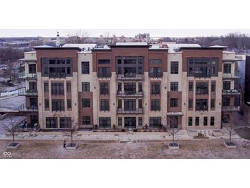 Modern condo building with brick and wood facade, featuring large windows and private balconies at 15 W Executive Dr # 104, Carmel, IN 46032