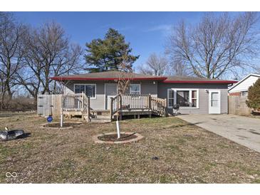 Charming single-story home with gray siding, red roof trim, inviting front porch and a small, tidy front yard at 2610 Caroline Ave, Indianapolis, IN 46218