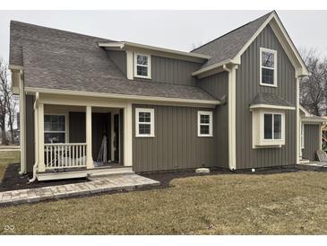 Charming home featuring vertical siding, a covered porch, and well-maintained landscaping at 307 S Main St, Whitestown, IN 46075