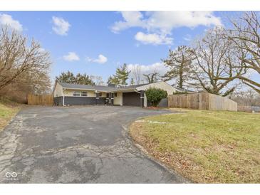 Ranch style home with long driveway, mature trees, neutral color palette, and attached garage at 3645 Glencairn Ln, Indianapolis, IN 46205