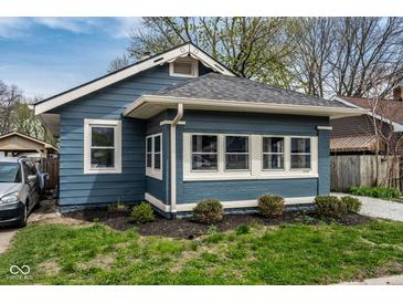Charming bungalow featuring a blue exterior, well-maintained landscaping and a number over the front window at 3708 Rockville Rd, Indianapolis, IN 46222