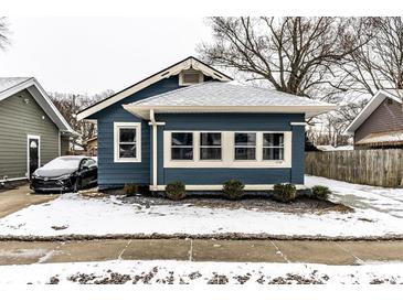 Charming blue home featuring a well-maintained lawn and a cozy covered porch at 3708 Rockville Rd, Indianapolis, IN 46222