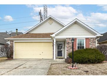 Charming single-story home featuring a brick facade, attached garage and inviting front yard at 5142 Pin Oak Dr, Indianapolis, IN 46254