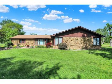 Charming ranch home with stone facade and well-maintained lawn under a partly cloudy sky at 5272 N Graham Rd, Whiteland, IN 46184