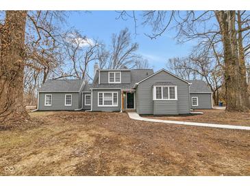 Charming gray home featuring updated windows and professional landscaping at 7999 Englewood Rd, Indianapolis, IN 46240