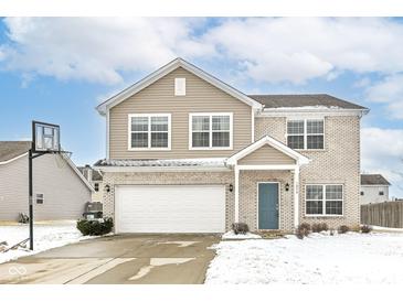 Charming two-story home with light brick and tan siding, complemented by a well-maintained yard and two-car garage at 1058 W Limestone Way, Fortville, IN 46040