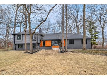 Stunning two-story home with modern gray brick, wood accents, and professional landscaping at 11035 W Lakeshore Dr, Carmel, IN 46033