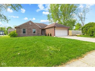 Beautiful single-story brick home with a green lawn and mature trees at 1135 Sherwood Dr, Danville, IN 46122