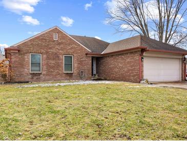 Charming brick home featuring a well-manicured lawn and attached garage at 1135 Sherwood Dr, Danville, IN 46122