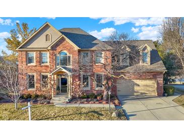 Traditional brick home with mature landscaping, two car garage, and a welcoming front porch at 9970 Southwind Dr, Indianapolis, IN 46256
