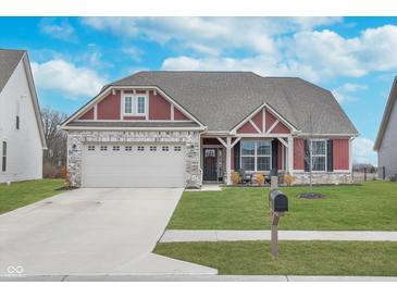 Charming home featuring a two-car garage, nicely manicured lawn, and stylish architectural details at 1051 Macoun Dr, Westfield, IN 46074