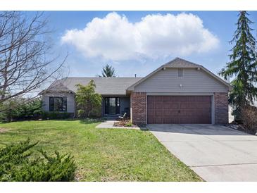 Charming ranch home featuring a brick facade, well-manicured lawn, and an attached two-car garage at 12205 Whitebark Dr, Indianapolis, IN 46236