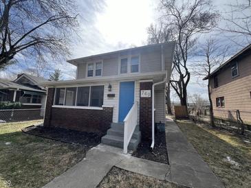 Charming two-story home featuring a welcoming blue front door and a classic brick-and-siding facade at 749 W 32Nd St, Indianapolis, IN 46208