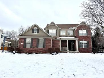 Attractive two-story brick home with a welcoming front porch and snow-covered yard at 14596 Toponas Pl, Fishers, IN 46040
