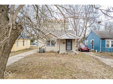 Charming single-Gathering home featuring a cozy front porch, mature trees, and neutral siding at 3829 N Temple Ave, Indianapolis, IN 46205