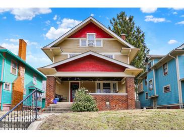 Charming two-story home with red accents and a welcoming front porch and an unkempt lawn at 4029 Broadway St, Indianapolis, IN 46205