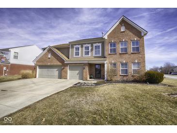 Stunning two-story brick home with a spacious three-car garage and well-maintained front yard at 5810 Grand Ave, Plainfield, IN 46168