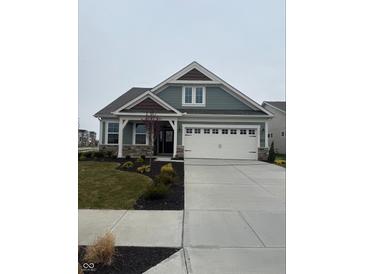 Charming single-Gathering home featuring a two-car garage, stone accents, and manicured landscaping at 7227 Bailow Ct, McCordsville, IN 46055