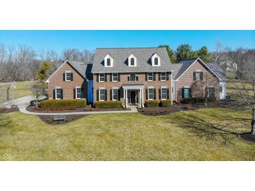 Stunning two-story brick home featuring black shutters, dormer windows, and manicured landscaping at 10120 Fox Trce, Zionsville, IN 46077