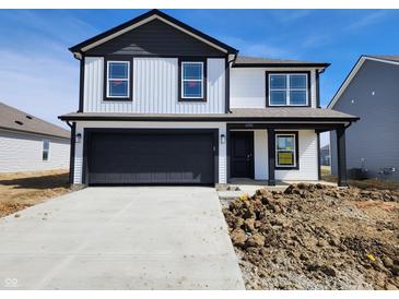 Charming two-story home boasts black and white siding, a spacious garage, and a pristine concrete driveway at 11295 N Quillow Way, Monrovia, IN 46157