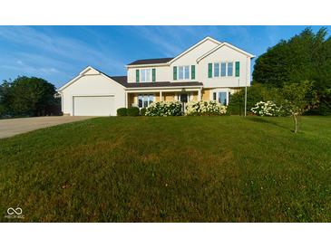 Traditional two-story home with white siding, green shutters and a well-manicured lawn and landscape at 13060 Wembly Cir, Carmel, IN 46033