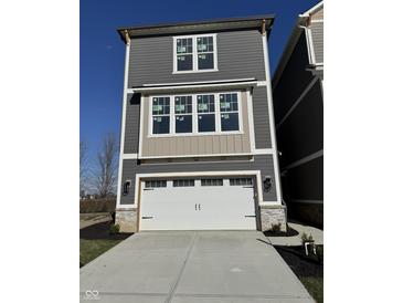 Charming two-story home featuring a white garage door, complementary gray siding, and ample natural light at 15407 Mystic Rock Dr, Carmel, IN 46033