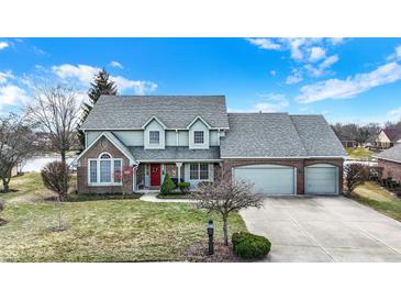 Charming two-story home with a well-manicured lawn and a welcoming red front door beneath a covered porch at 1852 Lakeside Ln, Indianapolis, IN 46229