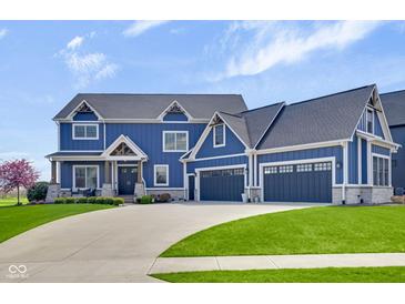 Beautiful two-story home with blue siding, stone accents, and a three-car garage at 20451 Chatham Hills Blvd, Westfield, IN 46074