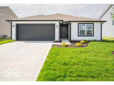 Charming single-story home boasting manicured lawn and modern black and white accents at 3261 W Keepsake Ln, Monrovia, IN 46157