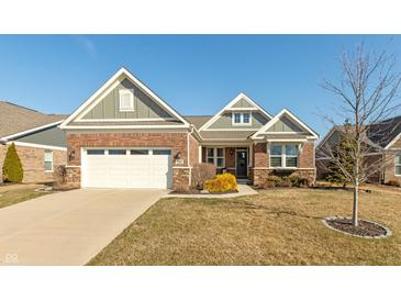 Charming brick home featuring attached garage, manicured landscaping, and inviting curb appeal at 3982 Abbotsford Dr, Westfield, IN 46074
