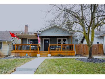 Charming home with a covered front porch, wooden railings, and decorative touches at 6047 Guilford Ave, Indianapolis, IN 46220