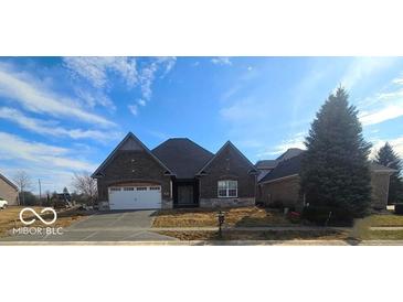 Attractive brick home featuring a two car garage, manicured lawn, and beautiful blue skies on a sunny day at 6641 Stone Pointe Way, Indianapolis, IN 46237