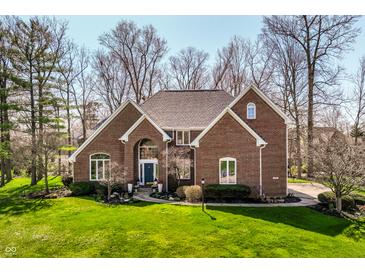 Charming brick home with a well-manicured lawn, mature trees, and a welcoming entrance at 8845 Otter Cove Cir, Indianapolis, IN 46236