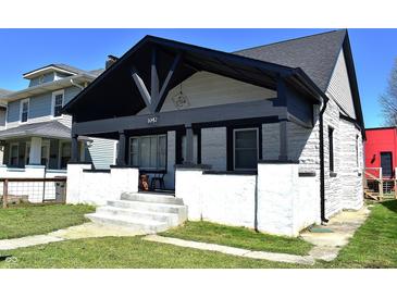 Charming home featuring a covered front porch with black trim and newly-painted stucco facade at 1042 Nelson Ave, Indianapolis, IN 46203