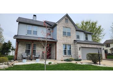 Charming two-story home featuring a brick facade, gray siding, attached garage, and well-manicured front lawn at 1501 Willshire Dr, Greenwood, IN 46143